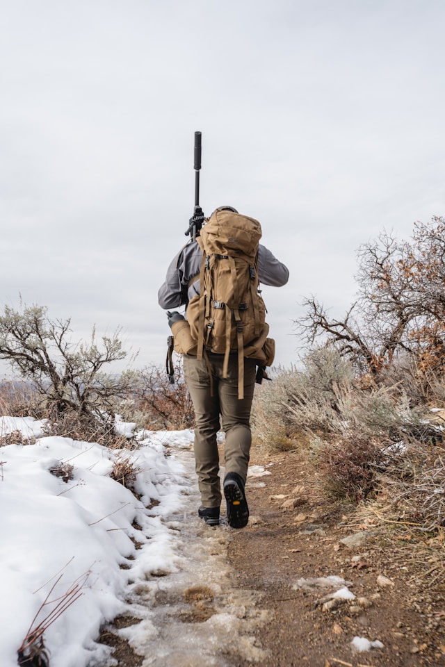 Hunter with gear and hunting rilfe with supperssor